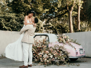 Fort Lauderdale Wedding Photographer, groom holding up bride next to car