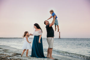 Fort Lauderdale Family Photographer, family of 4 playing at the beach with dad holding up daughter in the air