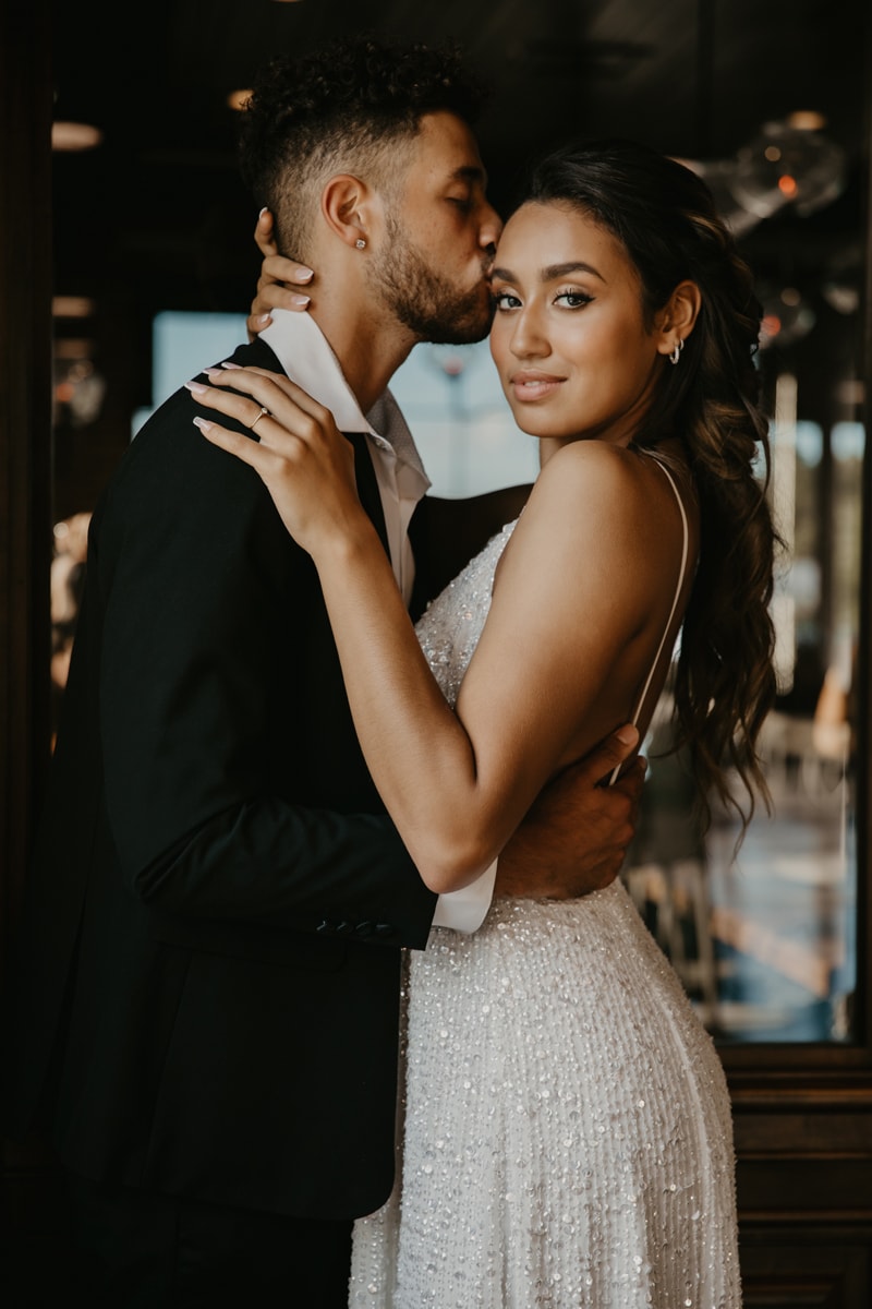 wedding photographer, man kisses his bride on the forehead