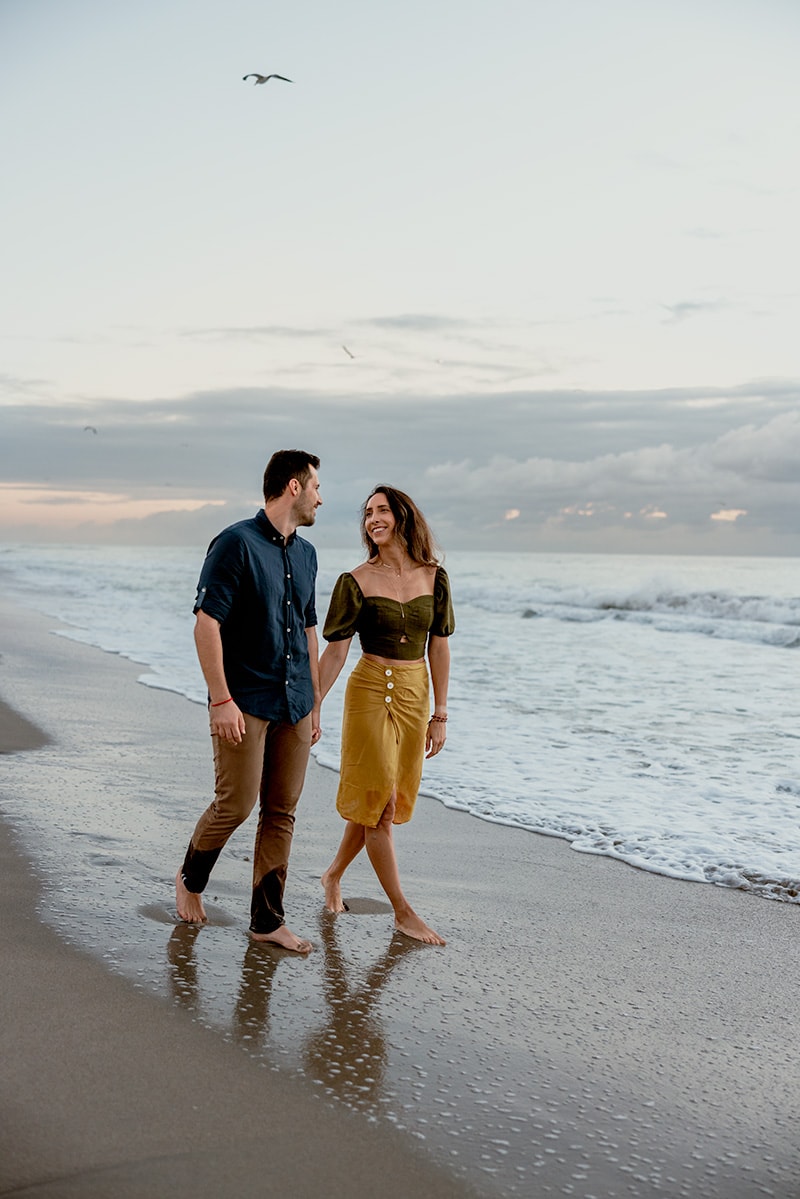 couple walking beach sunrise 
