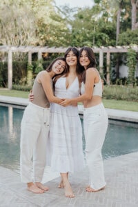 three sisters standing and hugging
