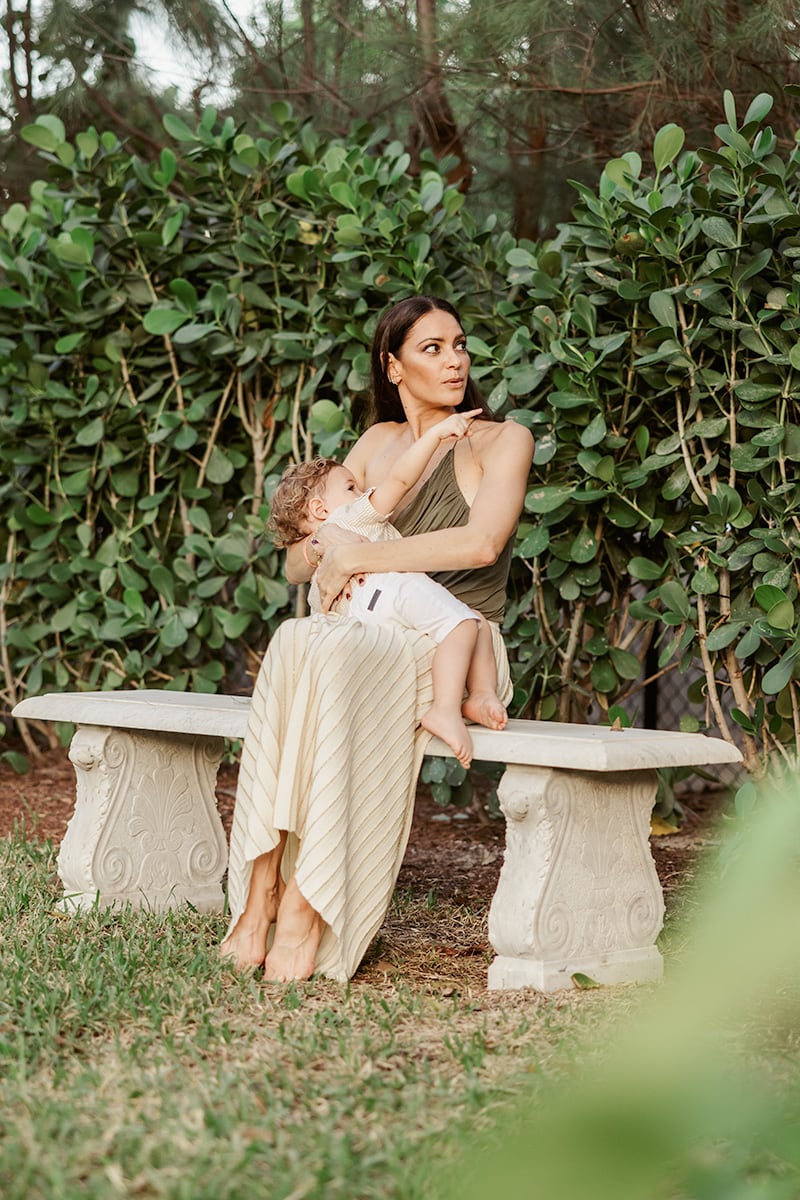 mother breastfeeding baby in backyard