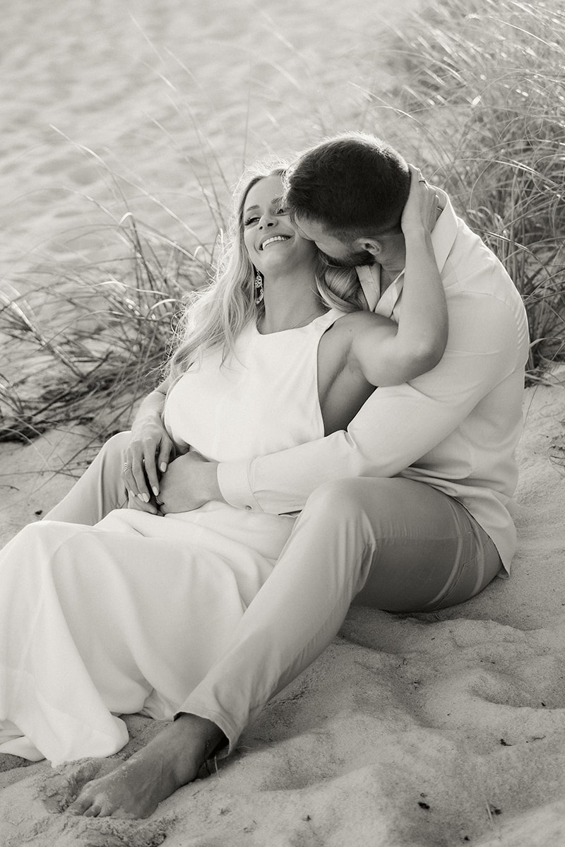 couple, black and white, beach, sand, sitting down