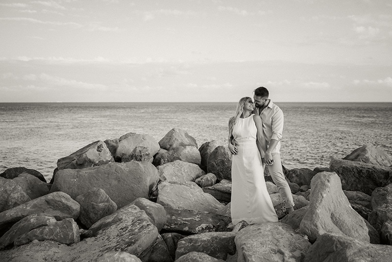 couple, bride and groom, rocks, black and white, beach