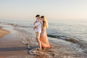 family of three at the beach during sunrise, mom pink dress
